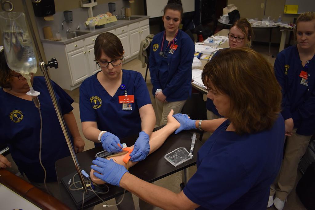 Nursing students using a practice arm